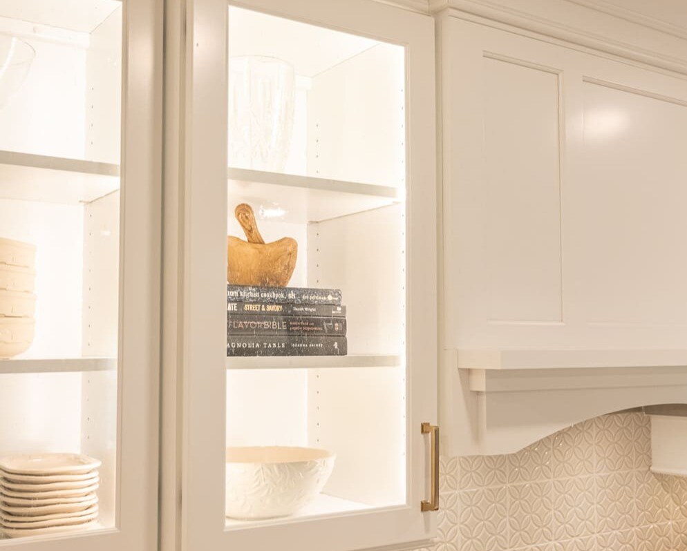 Glass-front cabinets with lighting in Cincinnati, OH kitchen remodel by Legacy Builders