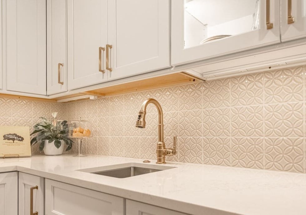 White cabinets and mosaic backsplash with brass fixtures in Cincinnati kitchen remodel by Legacy Builders