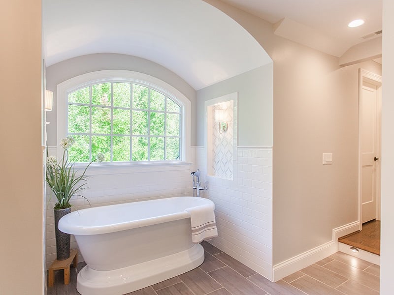 Cincinnati bathroom remodel with freestanding tub by window and tile flooring