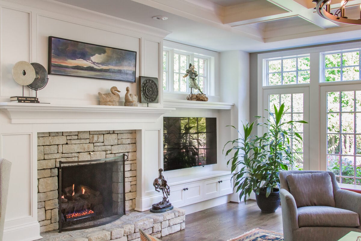 Fireplace with brick surround in Montgomery. Ohio home addition with natural light coming in from French doors to backyard