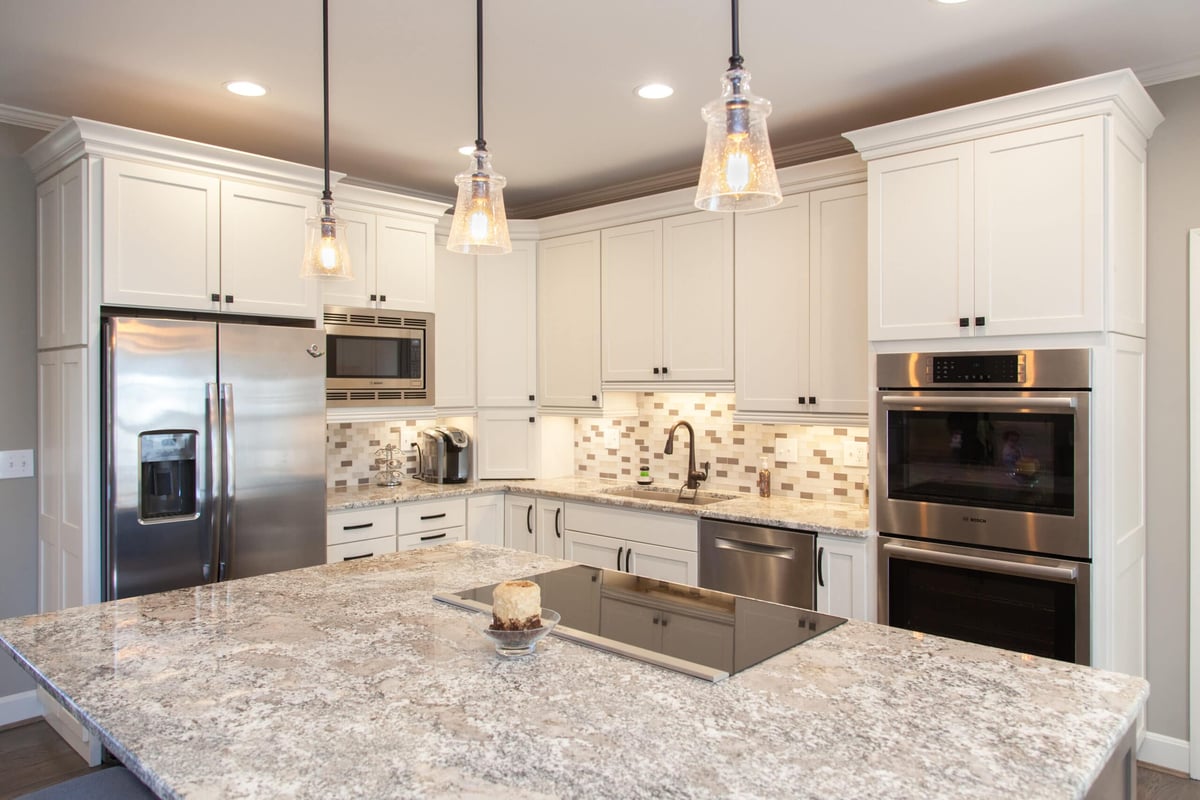 Montgomery, OH kitchen remodel with three pendant lights above kitchen island with high-end stovetop