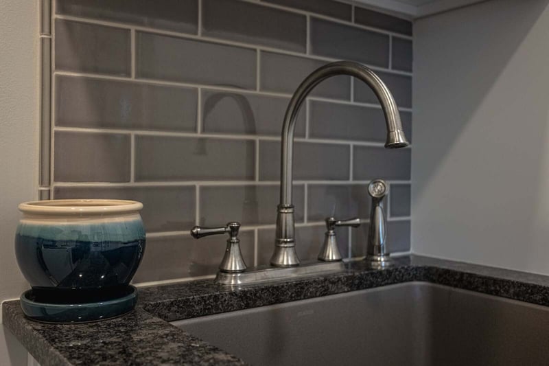 Stainless steel sink faucet with gray tile backsplash in Cincinnati, Ohio kitchen remodel by Legacy Builders