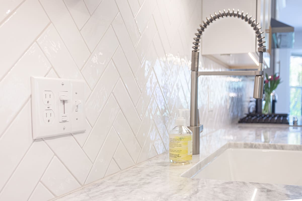 White herringbone pattern subway tile backsplash behind sink in Cincinnati, Ohio kitchen remodel by Legacy Builders