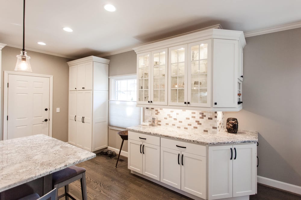 White kitchen cabinets in Madeira, OH kitchen remodel by Legacy Builders with glass paneling on upper cabinets