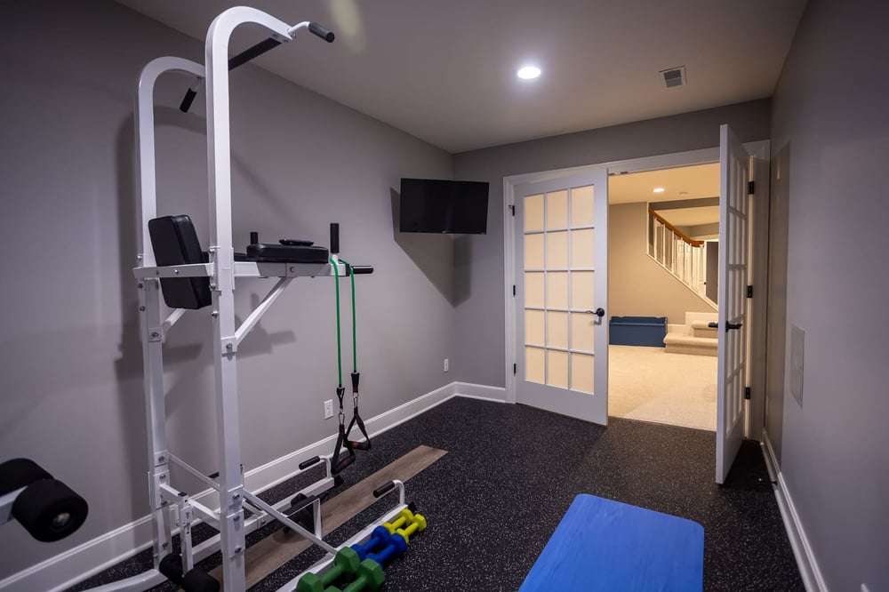 Basement renovation gym area with recessed lighting and gym equipment