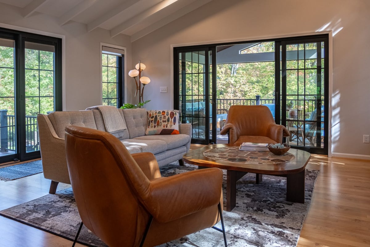 Two chairs and couch in great room addition by Legacy Builders with sliding doors open to backyard