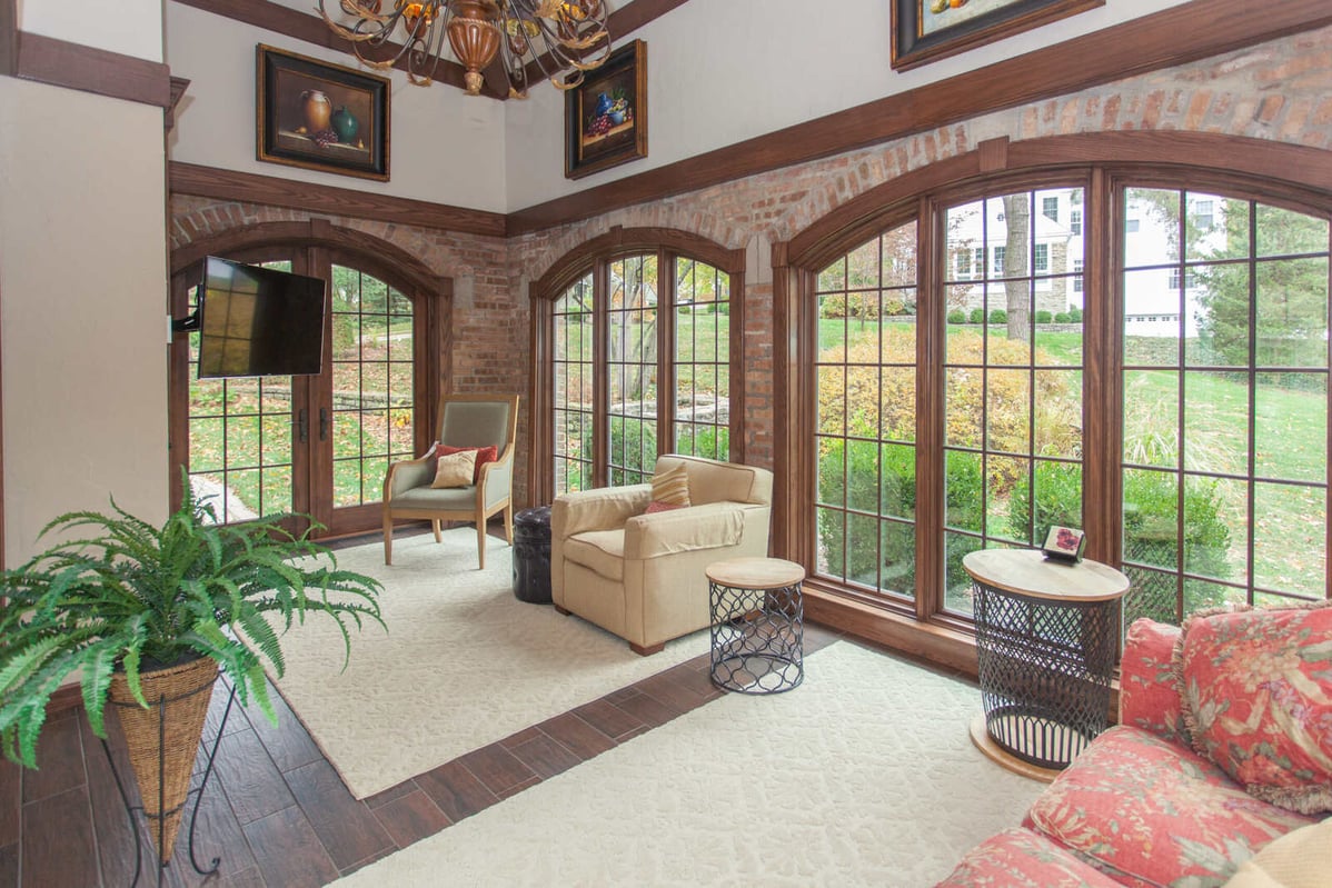 Hyde Park sunroom with chairs and tv by Legacy Builders