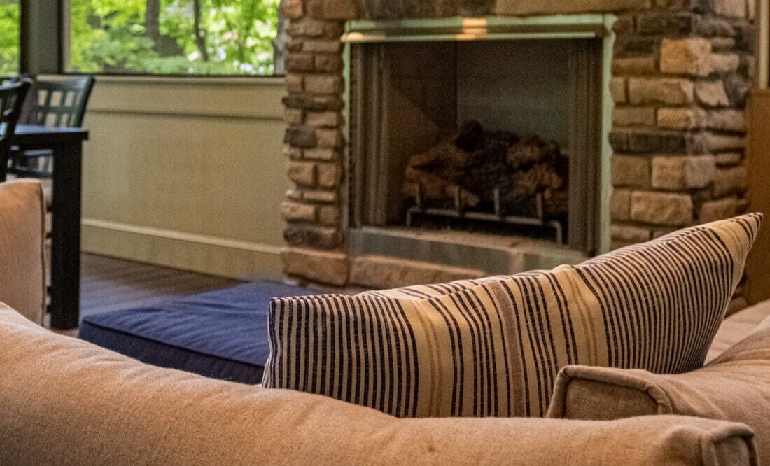 Stone fireplace and wall-mounted TV in home addition in Symmes Township, Ohio, by Legacy Builders