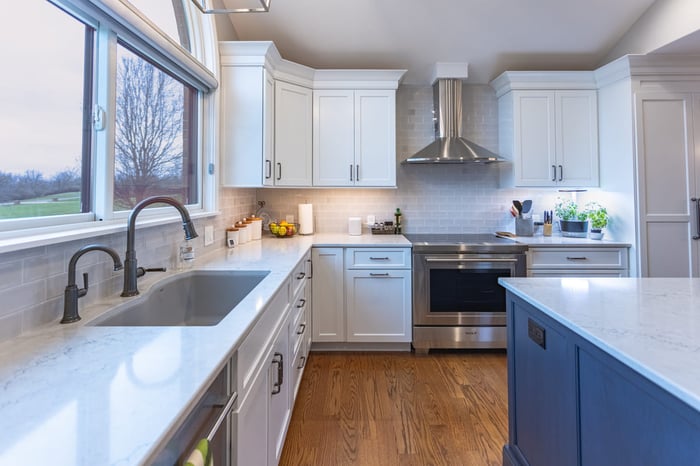 Modern kitchen remodel with white shaker cabinets cabinets and window above white countertops by Legacy Builders