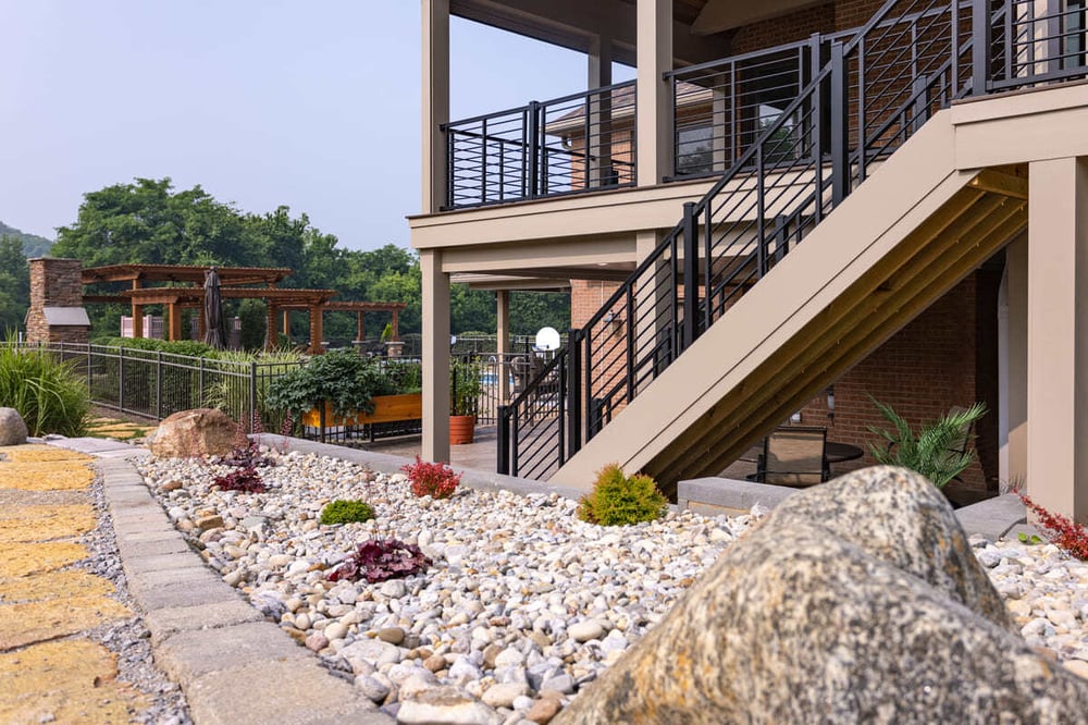 Close-up curved retaining wall near patio stairs and landscaping in a remodeled outdoor space in Cincinnati, OH