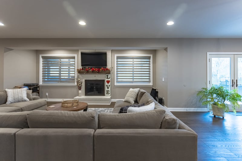 View of basement living space with fireplace and glass doors to outside