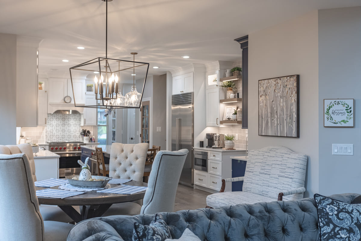 Pendant light fixture above dining room table with view of kitchen in back by Legacy Builders Group